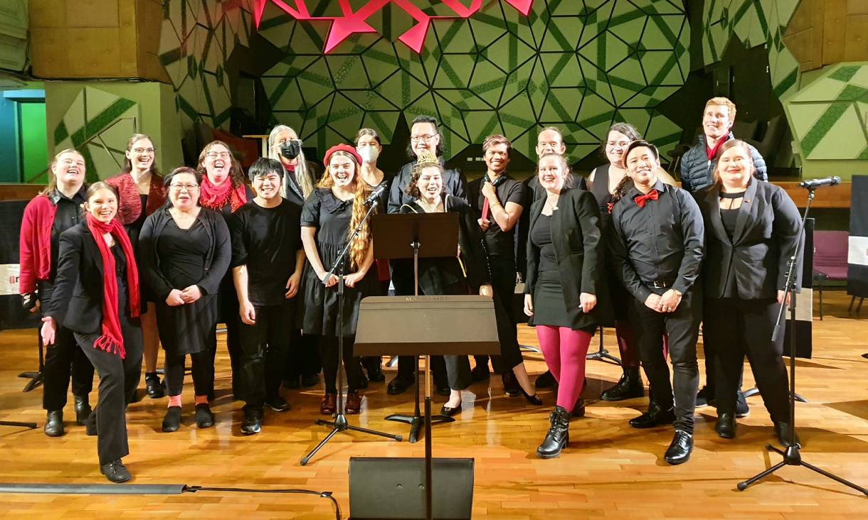 Choir standing on stage smiling